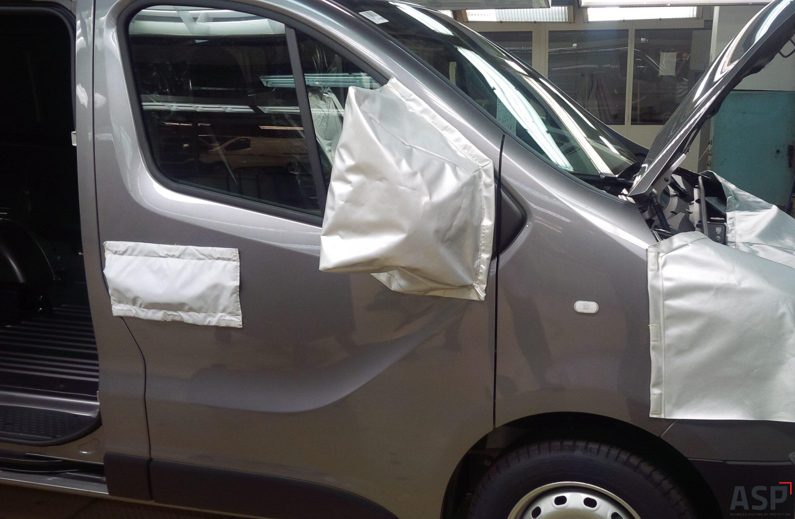 Veicolo da trasporto, un piccolo camion grigio in cui le aree più sensibili sono protette da un tessuto.