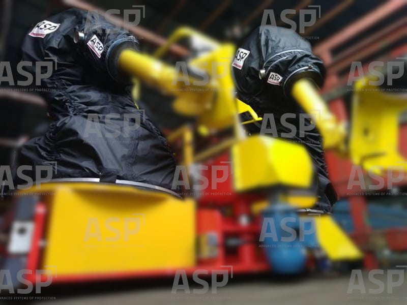 due robot industriali gialli, uno accanto all'altro, protetti da due coperture nere per ambienti ATEX con atmosfere esplosive